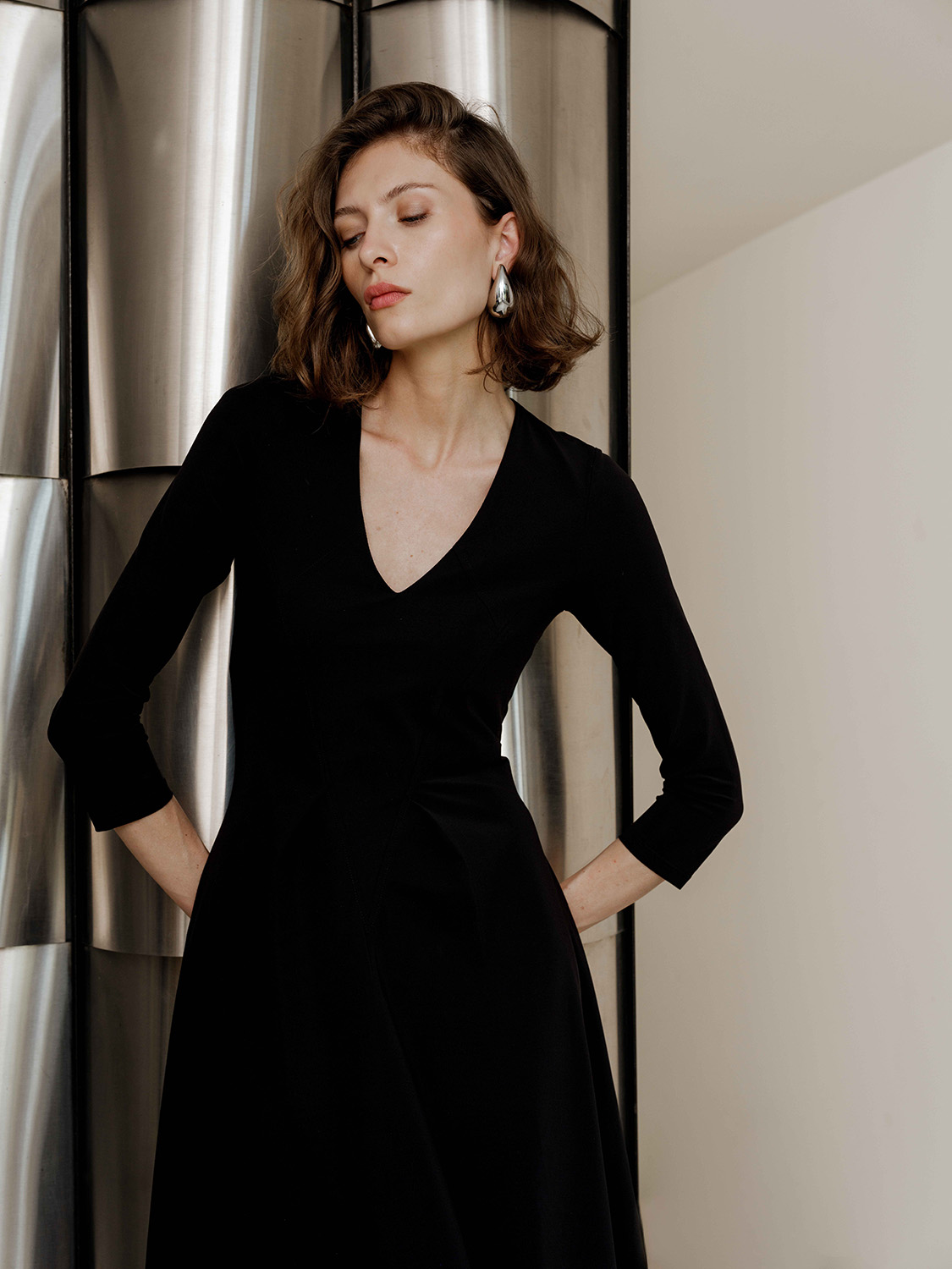INDIES - SPRING 25 - HD_-16 Woman in black silk midi dress with gentle smile and flattering drape.