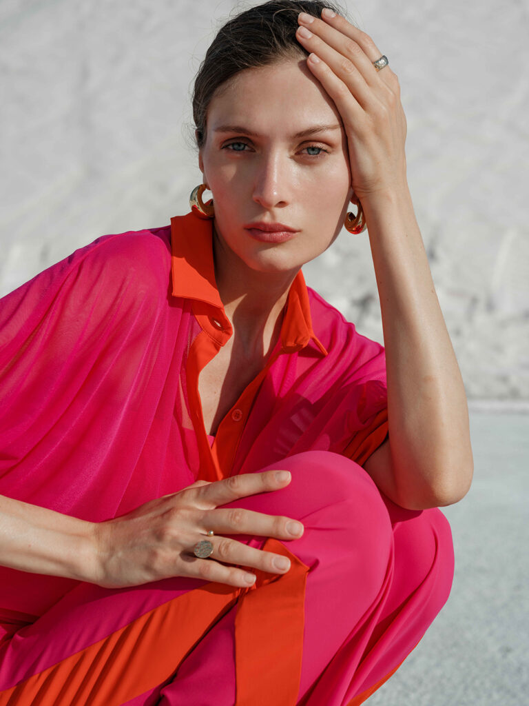 Woman in orange and pink button-down and matching pants.