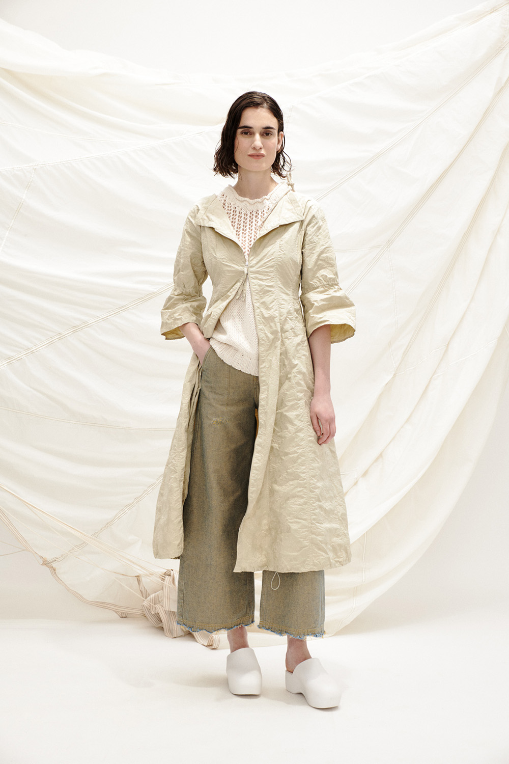 hat TAMO 40103-30 _ dress TAJA 40103-30 _ knit top OTIS_pants BONDO_Look_12_703 (7) Woman in an off-white trench coat and knit set with modern silhouette.