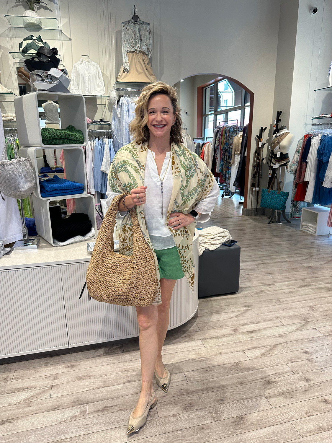 Capsule-Wardrobe-2 Fringe & Form's store owner’s green designer outfit smiling beside boutique shelves.