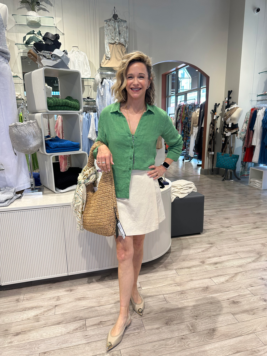 Capsule Outfit Summer time capsule outfit includes a white skirt and green shirt half tucked.