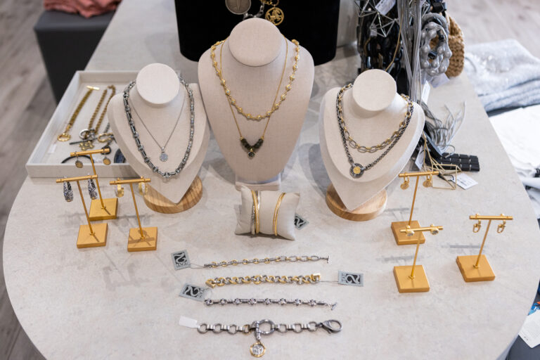 Shelf with statement earrings and necklaces on display at Fringe & Form women's clothier.