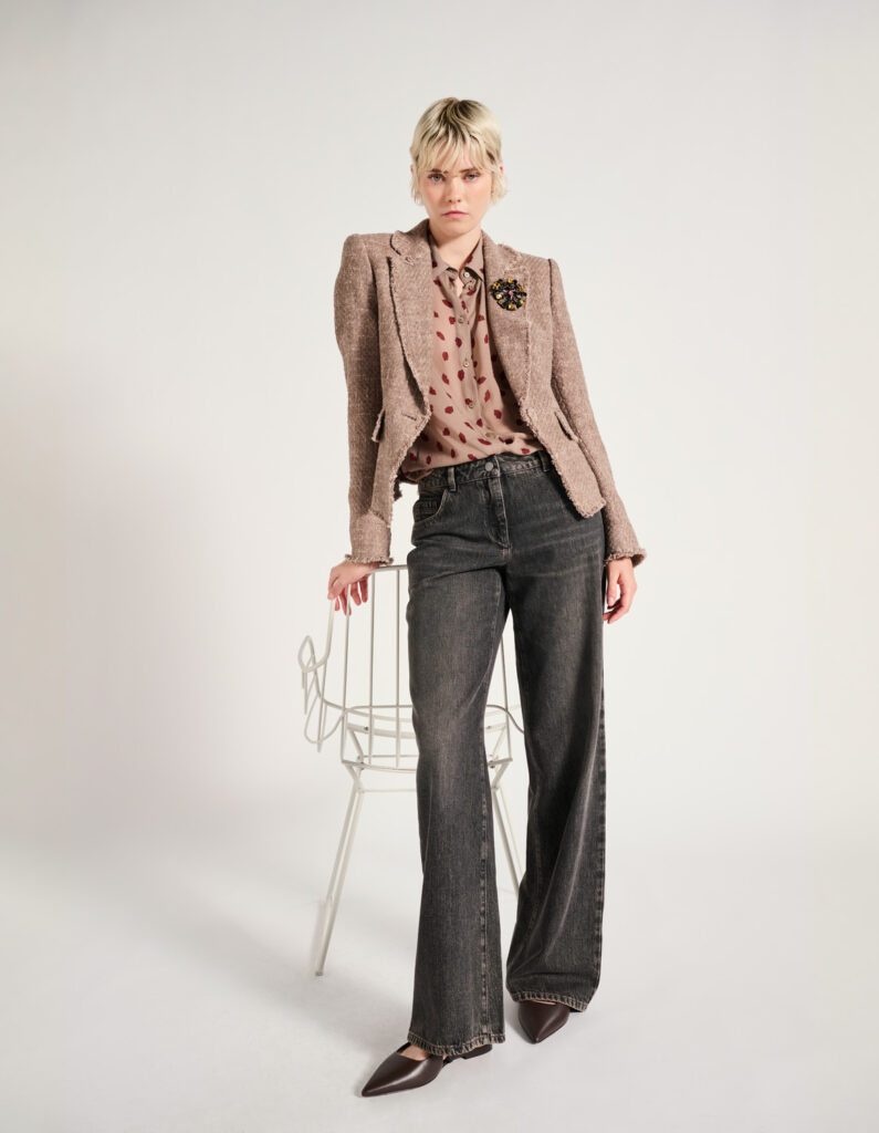 Luisa Cerano Jeans Jacket and Blouse A woman leans on a chair wearing grey jeans and a professional jacket with matching blouse.
